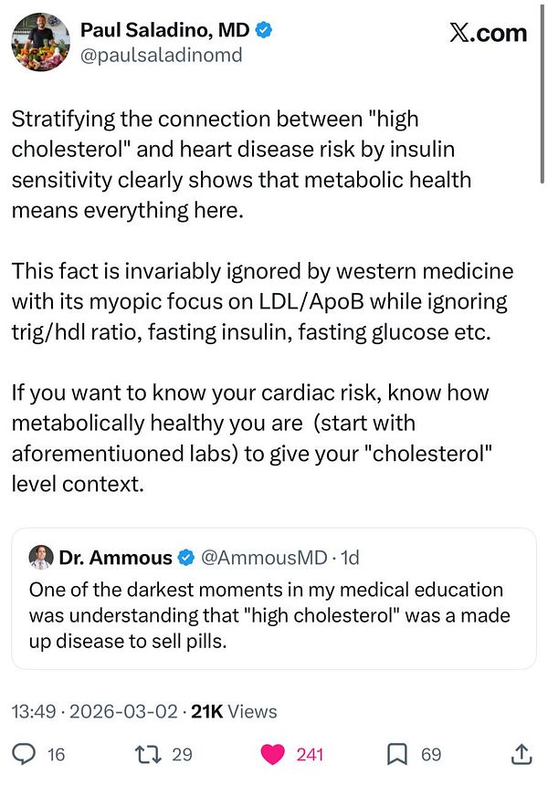 Portrait of a man with long hair and a beard, wearing a dark shirt, against a dark background.