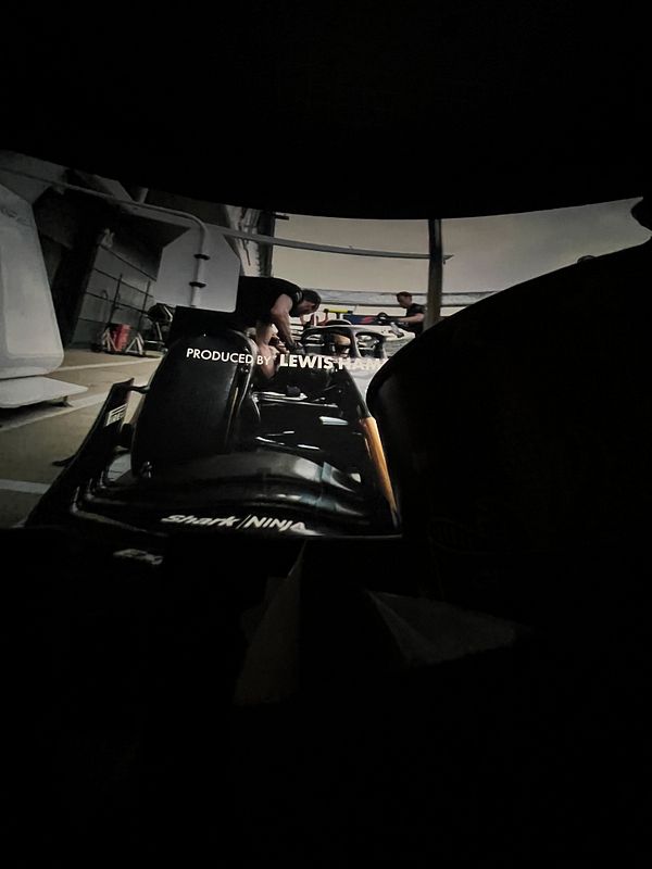 The image captures a scene from an F1 movie being projected on a screen.