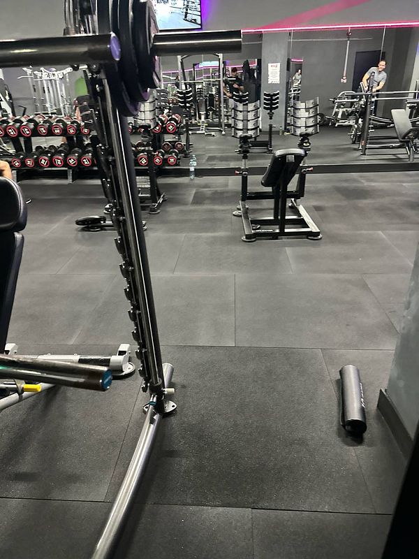 The image captures a gym interior featuring various workout equipment.