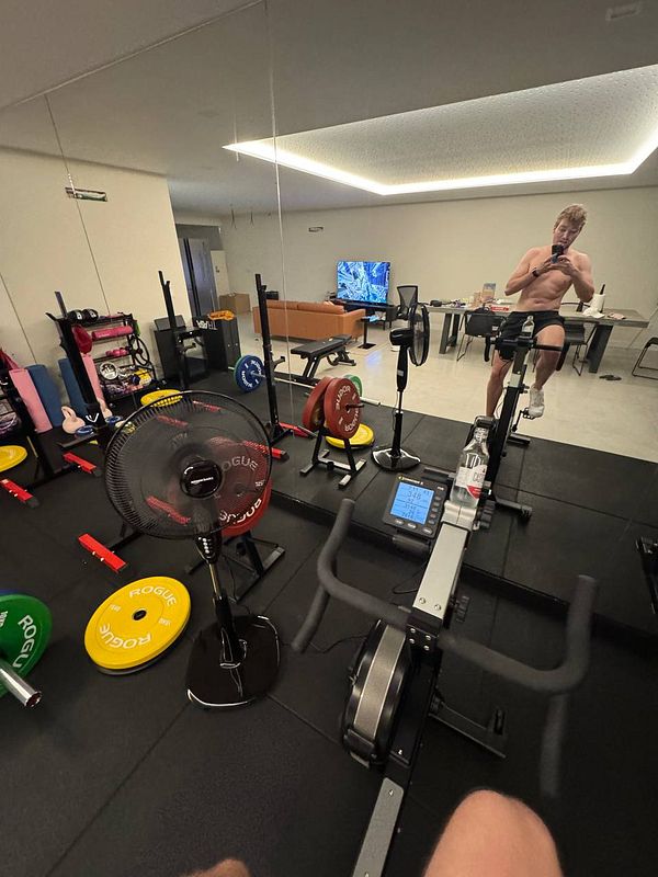A home gym setup featuring various workout equipment and a person exercising.