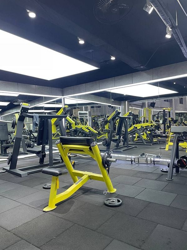 A modern gym interior featuring various workout equipment.