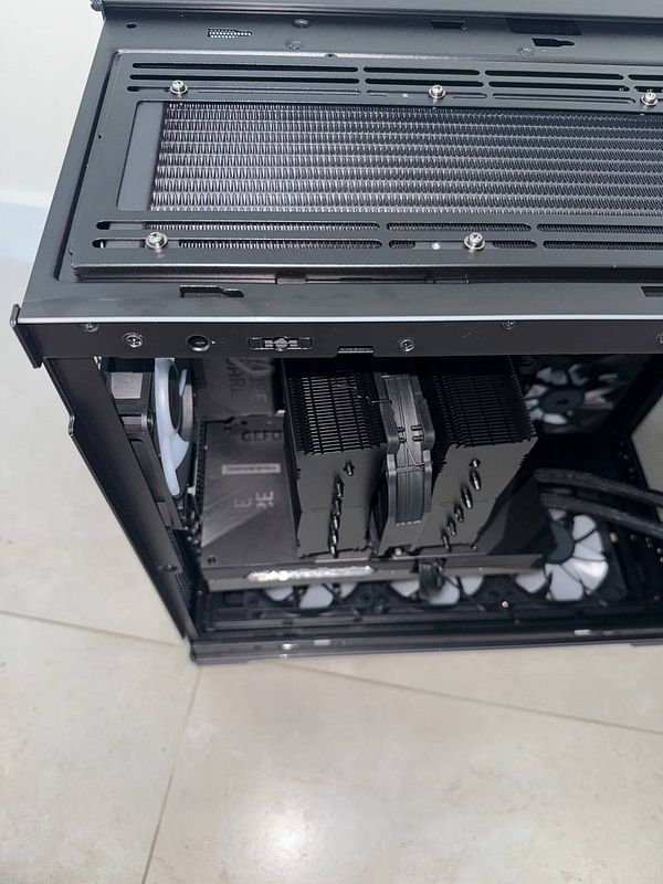 The image depicts a partially assembled computer case with a CPU cooler that is not fully attached.