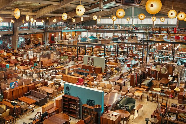 A spacious vintage store filled with a variety of furniture and decor items.