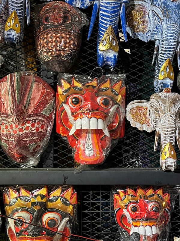 A vibrant display of traditional masks and decorative items found in a market.