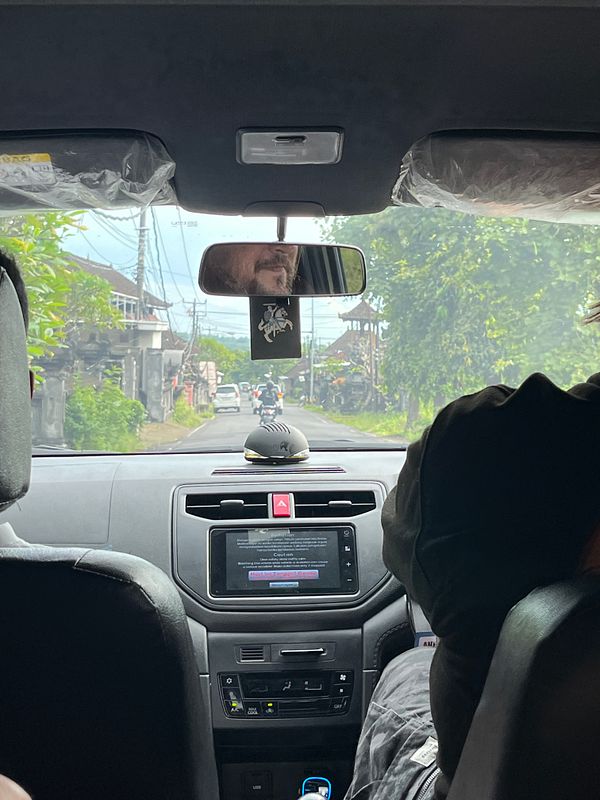 The image captures the view from inside a car, showing the road ahead and the dashboard.