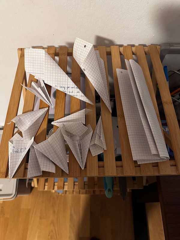 A collection of folded paper notes arranged on a wooden surface.