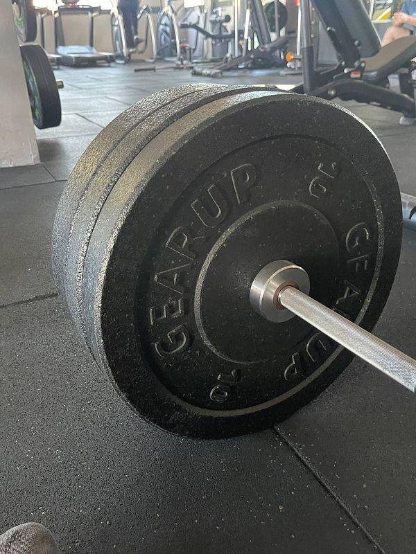 A close-up view of a weight plate on a gym floor.