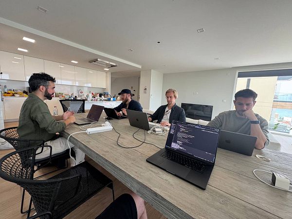 A group of four individuals is engaged in a coworking session at a modern workspace.