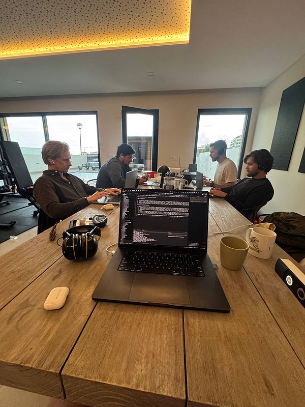 A group of four individuals is engaged in a coworking session at a modern workspace.