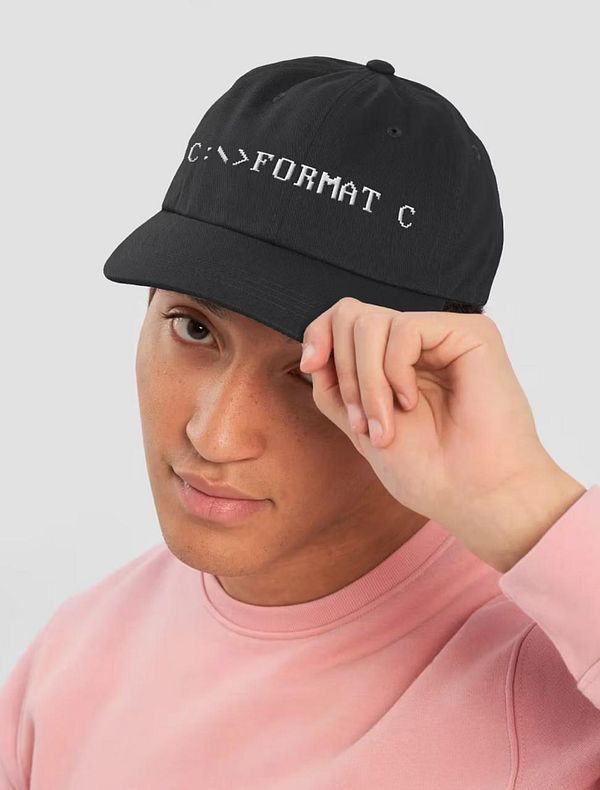 A young man wearing a black cap with a computer command printed on it.