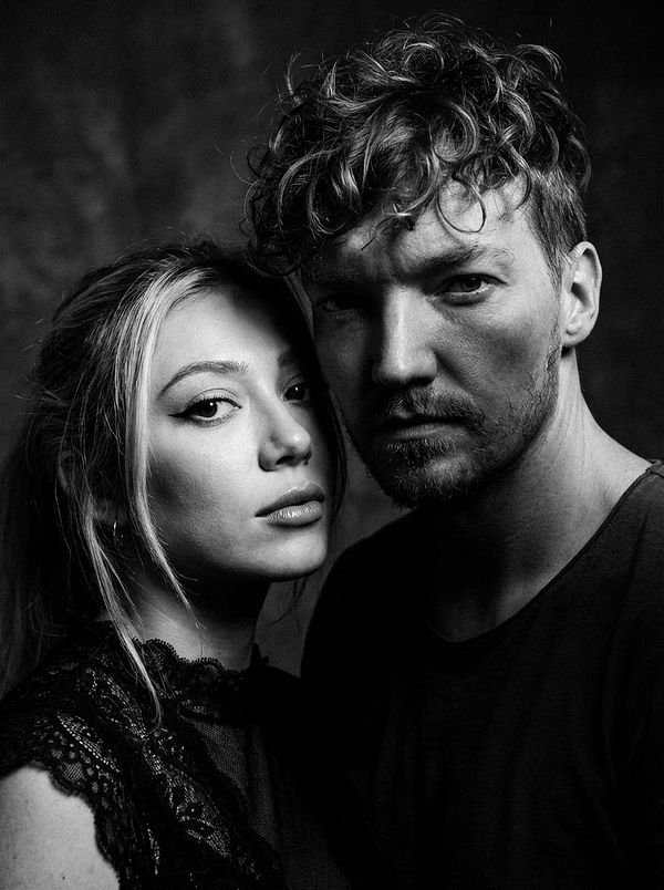 A striking black and white portrait of a man and woman closely positioned together.