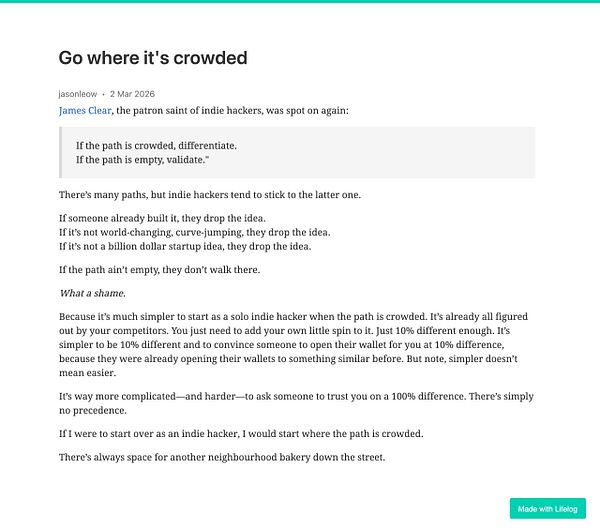 A vibrant beach scene crowded with people under multicolored umbrellas on a sunny day near a turquoise-blue sea with a clear sky.