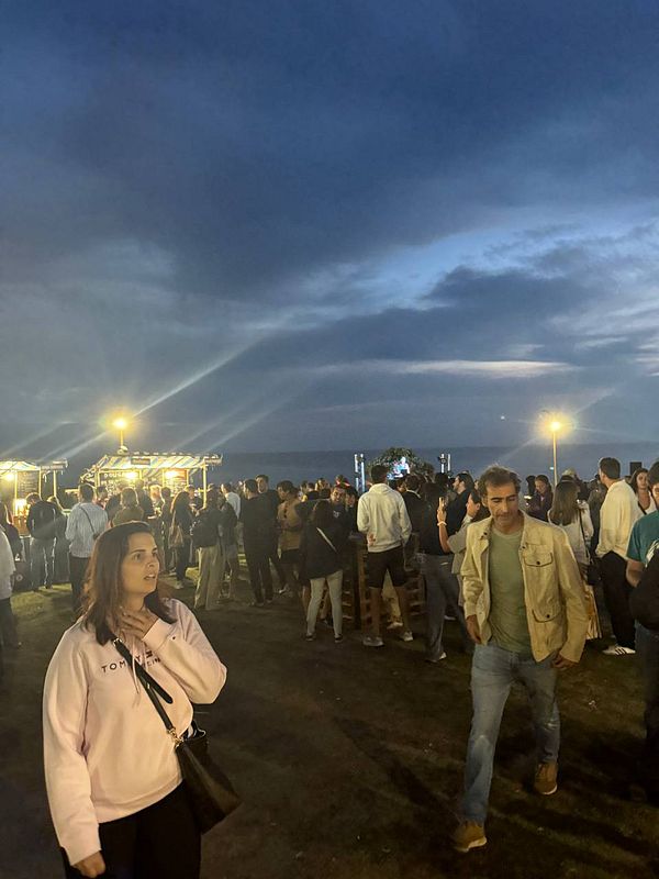 A lively outdoor festival scene at dusk with a crowd enjoying the Beerceira festival.