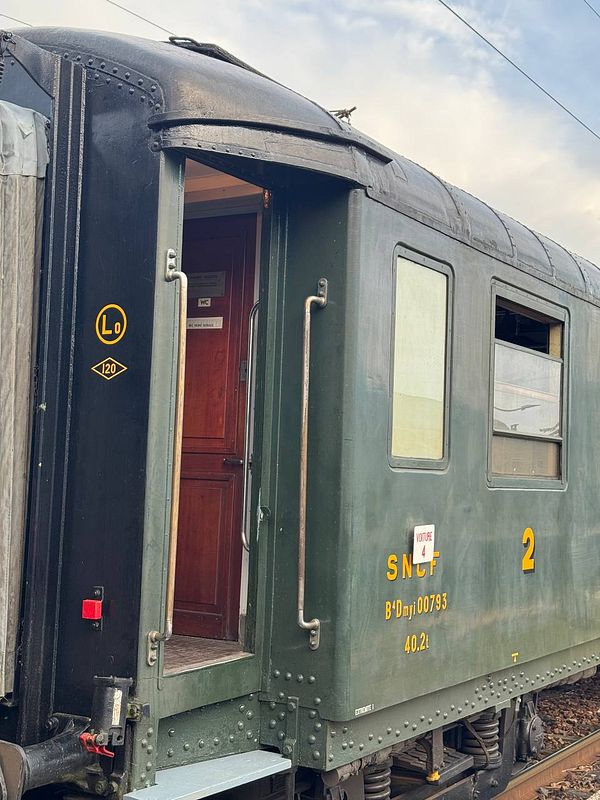A vintage train car from the SNCF, showcasing its exterior and entrance.