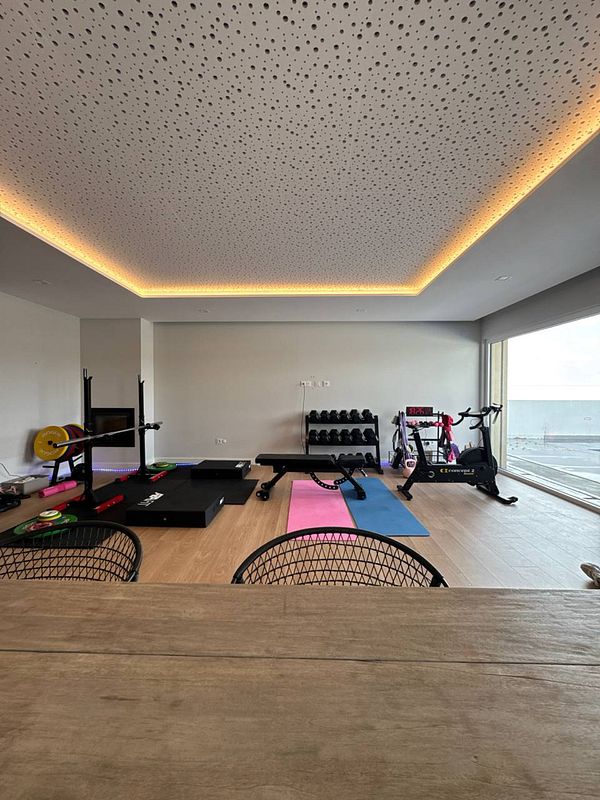 A modern home gym space featuring various workout equipment and a bright, airy atmosphere.