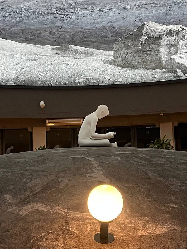 A serene spa interior featuring a white sculpture and a large mural.