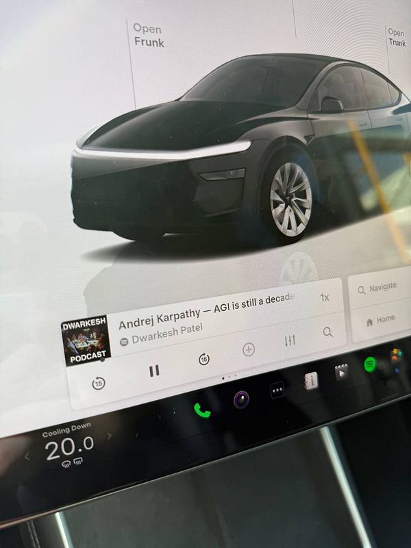 The image displays the touchscreen interface of a Tesla Model Y, featuring a podcast player and a 3D model of the car.