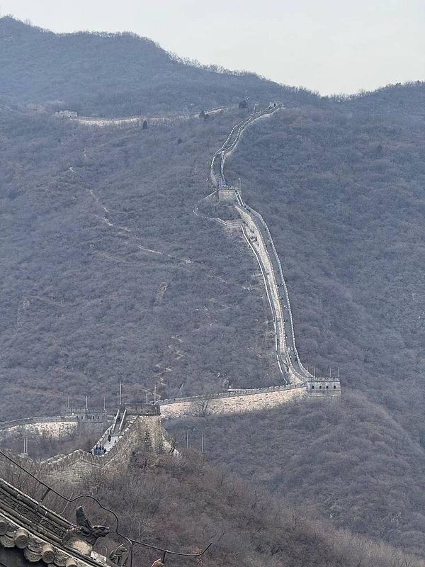 A panoramic view of the Great Wall of China winding through mountainous terrain.