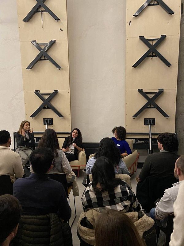 A panel discussion featuring three women in front of an audience.