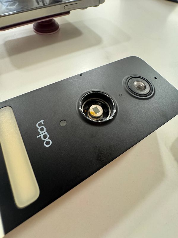 A damaged Tapo doorbell with visible water damage and a cracked motion sensor.