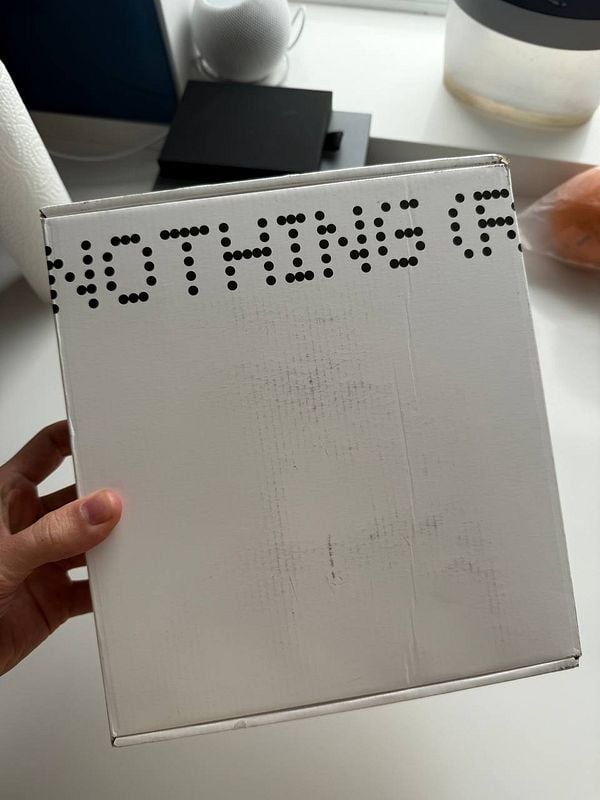 A person is holding a white box with the word 'NOTHING' printed on it.