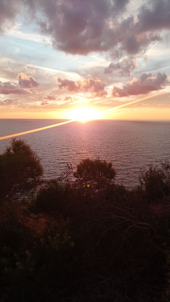 A stunning sunset over the ocean with vibrant colors and clouds.