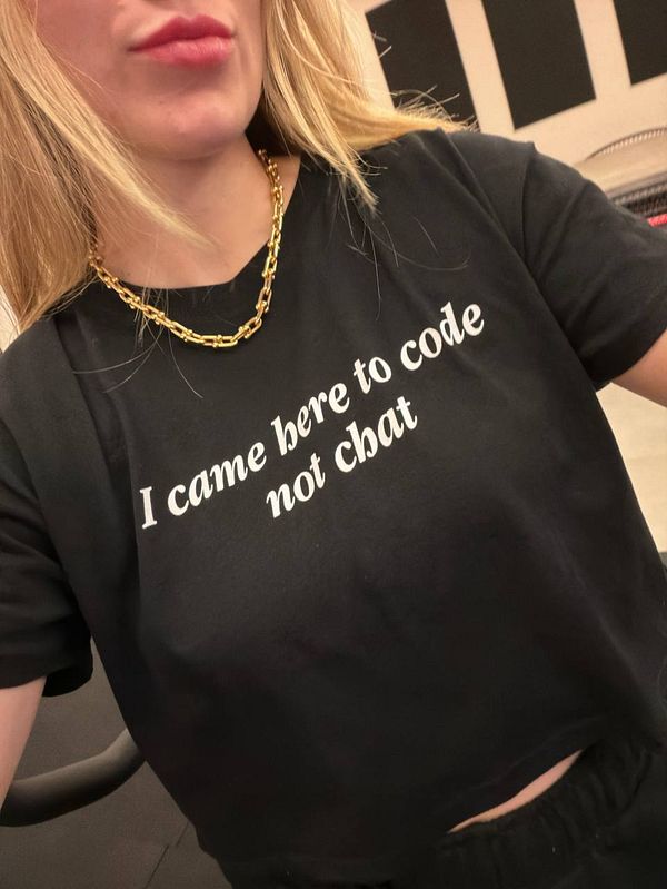 A person is wearing a black t-shirt with a humorous coding-related message.