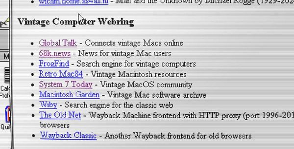 A vintage computer setup featuring a beige CRT monitor atop a keyboard and other peripherals on a desk.