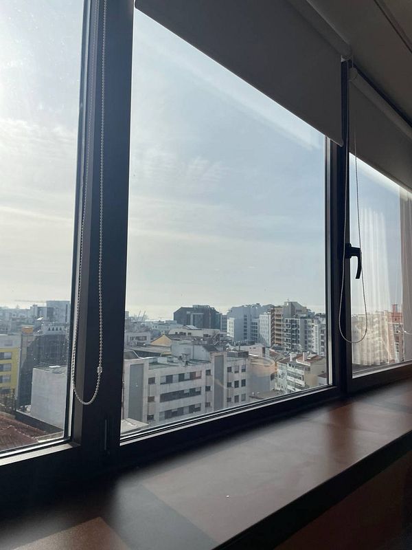 A view from a window overlooking a cityscape in Lisbon.