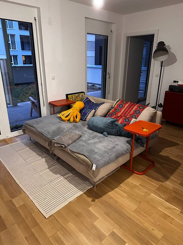 A cozy living room setup featuring a sofa, colorful cushions, and vibrant side tables.