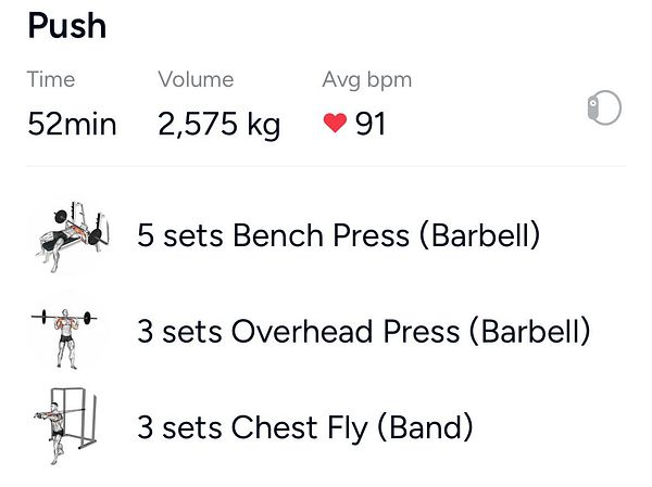 A man lifting a heavy barbell overhead in a gym setting.