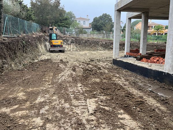 A construction site with heavy machinery and a partially built structure.