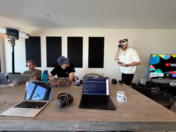 A group of people working together in a bright coworking space with colorful furniture and plants.