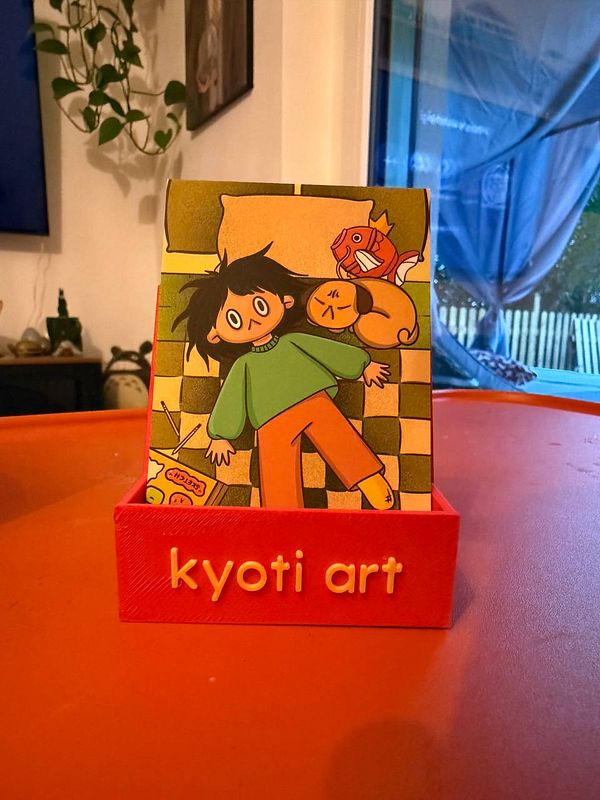 Close-up photo of a sleek, black leather business card holder on a dark surface.