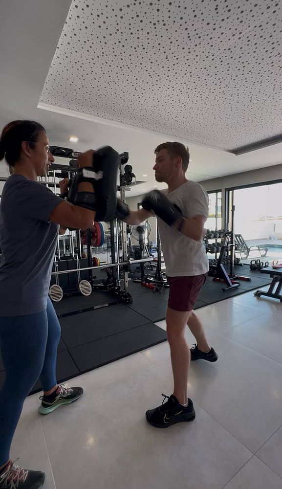 A personal training session is taking place in a gym setting.