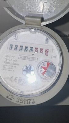 The image displays a water meter with visible readings and technical specifications.