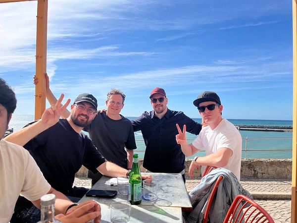 Group photo of nearly 20 people gathered indoors celebrating the success of Ruby on Waves #1 event in a cozy wood-paneled room.