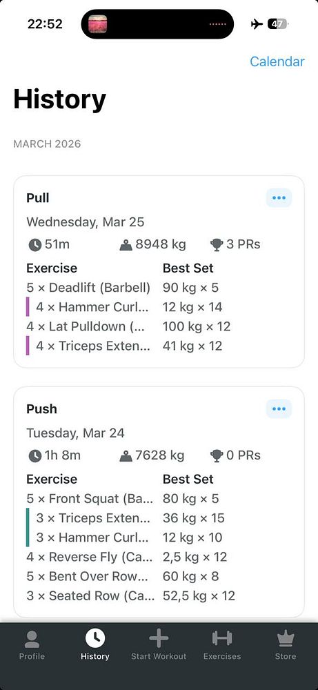 A young man lifting barbells in a gym while drenched in sweat.