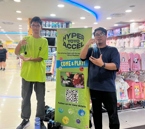Two individuals are demonstrating yoyo tricks in a store setting.