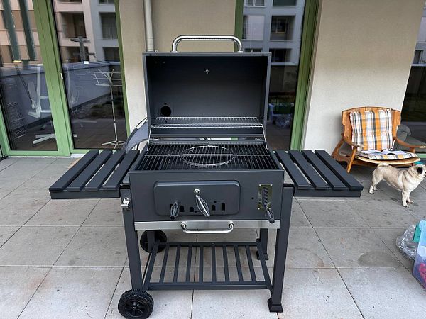 A newly assembled barbecue grill is displayed on a patio.