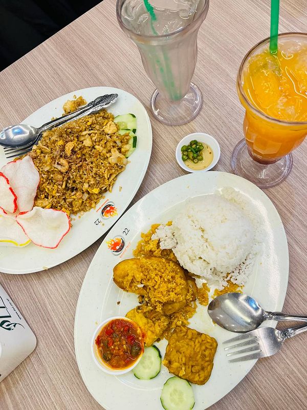 A delicious spread featuring Nasi Ayam Penyet and fried rice, accompanied by drinks.
