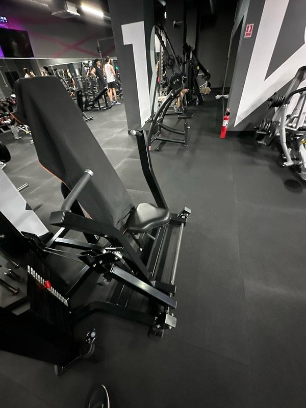 A gym interior featuring exercise equipment and individuals working out.
