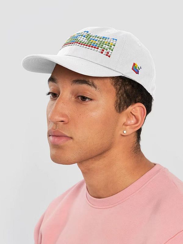 A young man is wearing a white cap featuring a colorful pixelated design on the front.