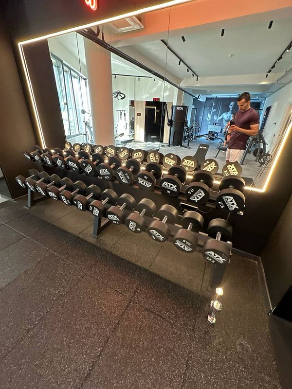 A well-organized gym area featuring a rack of dumbbells and a mirror.