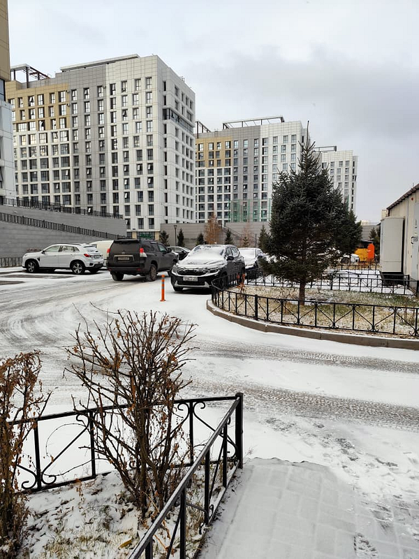 A winter scene featuring snow-covered streets and modern buildings.