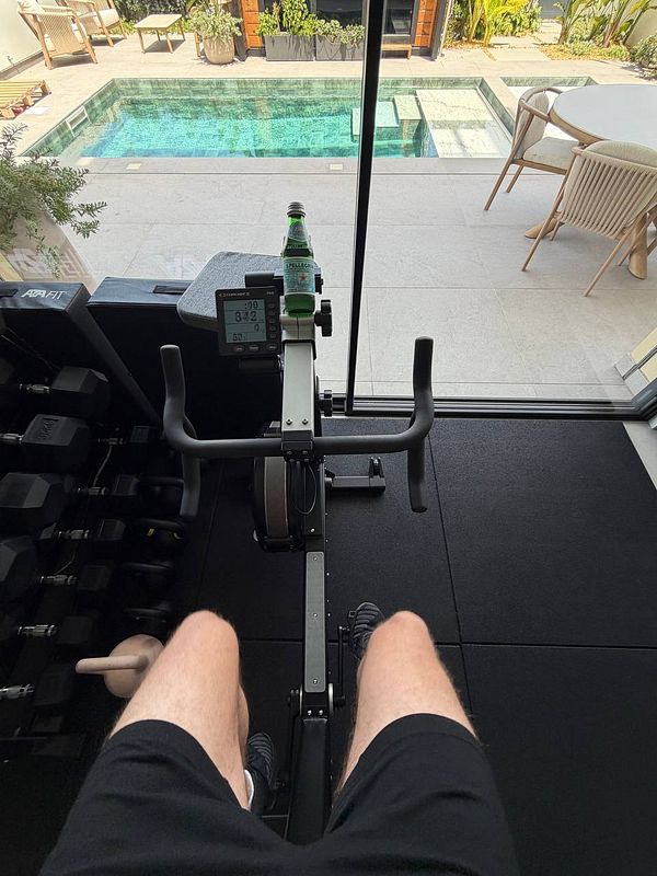 A woman is running on a treadmill in a modern gym setting, focusing on cardio exercise.