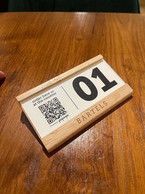 A table number sign with a QR code for ordering food at a restaurant.
