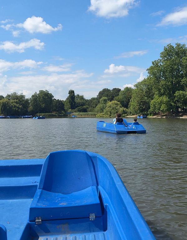 A serene scene of people enjoying pedalo boating in Regent's Park.