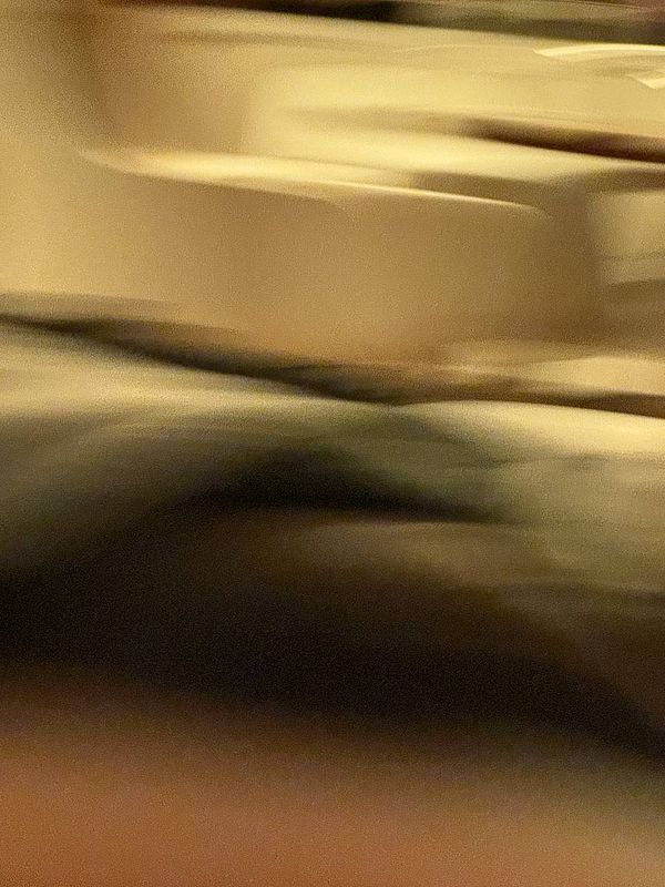 The image is a blurred and abstract representation of a scene, likely taken indoors.