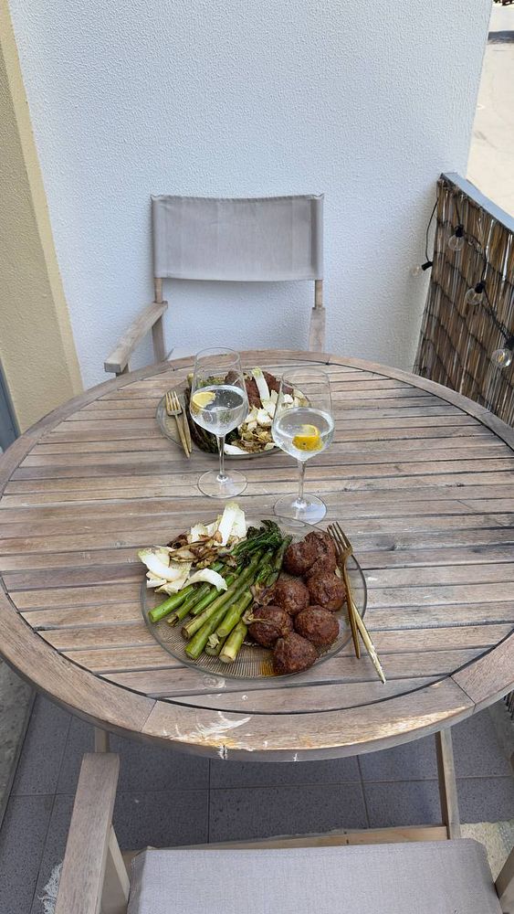 A clean and healthy meal is beautifully arranged on a wooden table on a balcony.